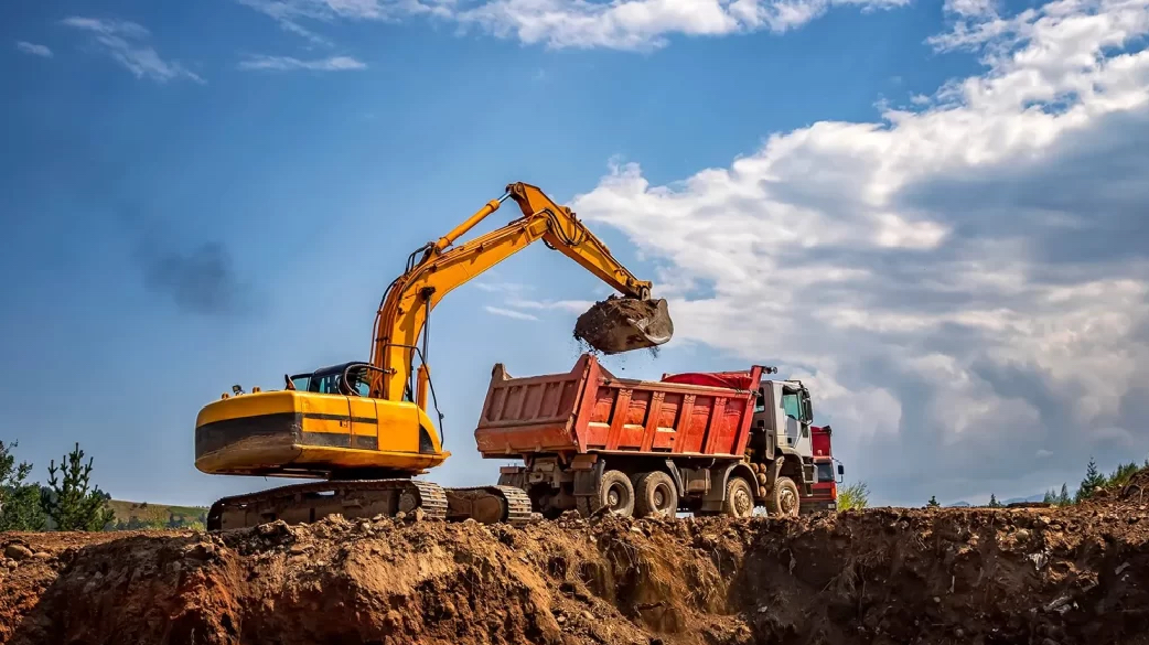 Foto de excavadora cargando camión.
